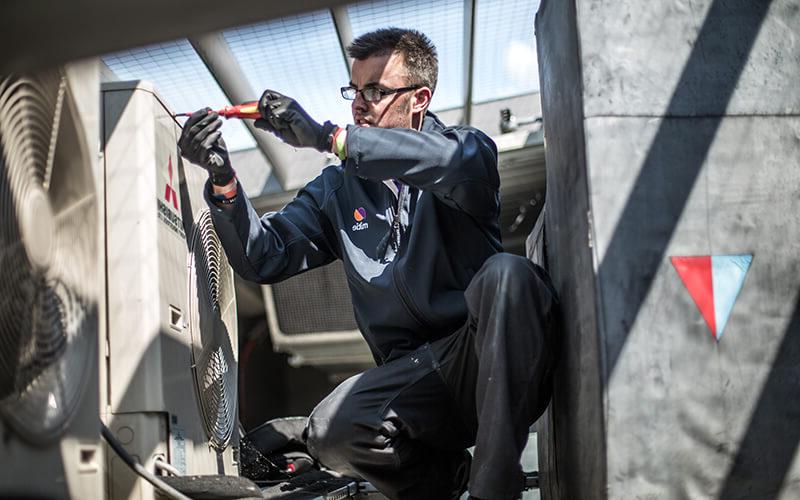 Male Mitie engineer fixing a fan